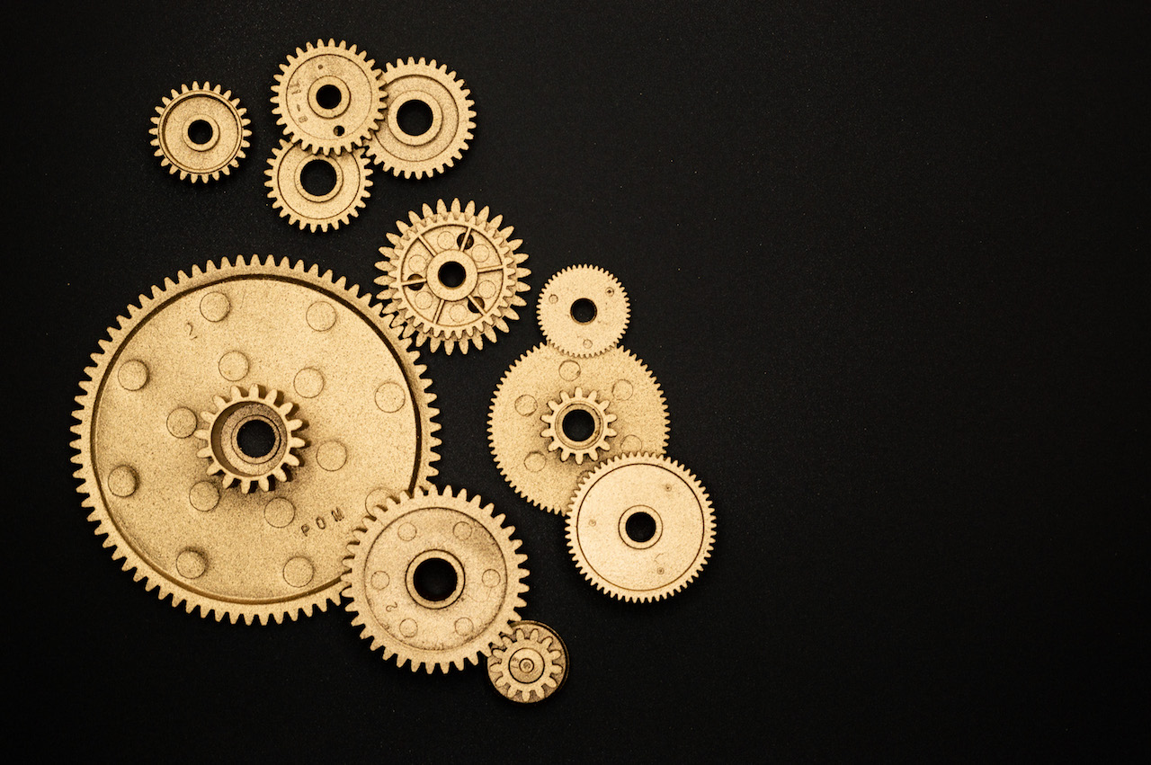 set of golden gears on black background Dendrino